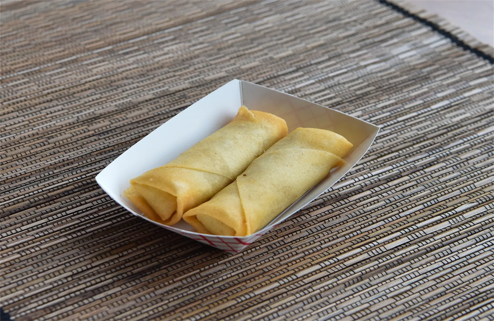 Two crispy fried spring rolls in paper tray at Magic Wok, a Asian Restaurant in Tupelo